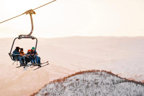 a group of people riding a ski lift at Hovdestøylen in Hovden