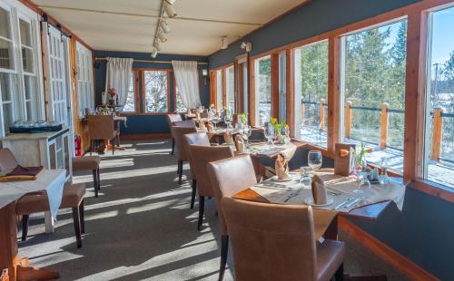a dining room with tables and chairs and windows at Heather Lodge in Minden