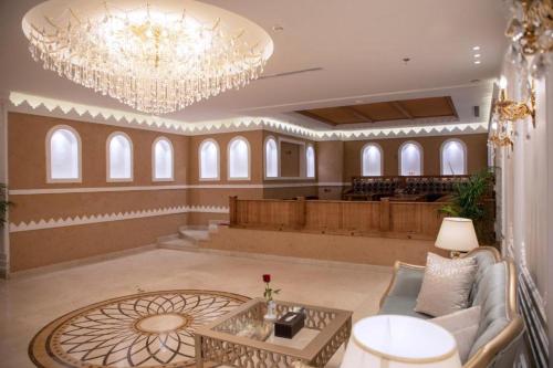 eine große Lobby mit einem Kronleuchter und einem Tisch in der Unterkunft Bellevue Park Hotel in Ta'if