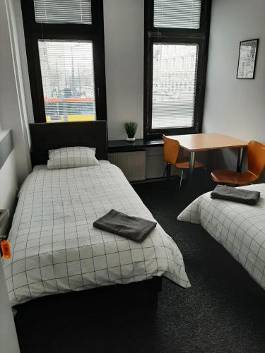 a bedroom with two beds and a table and chairs at Aleja "Solidarności" in Warsaw