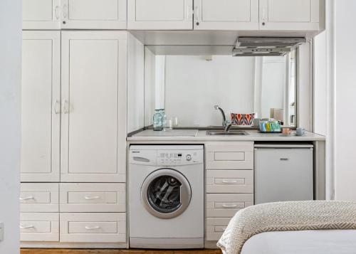 a white kitchen with a washing machine and a sink at BLUE PERA HOUSE in Istanbul