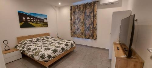 LA PIANETTA case vacanze في باليدورو: غرفة نوم بسرير ودهان على الحائط