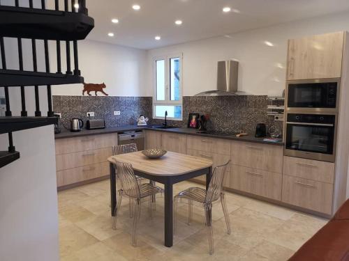 une cuisine avec une table et des chaises dans une cuisine dans l'établissement CHEZ PERLE à LEVIE, logement entier de type T4, à Levie