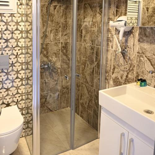a bathroom with a shower and a toilet and a sink at ROXX ROYAL HOTEL in Kuşadası