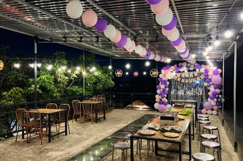 a party with tables and chairs and purple and white balloons at Lacasa home&coffee Mộc Châu in Mộc Châu