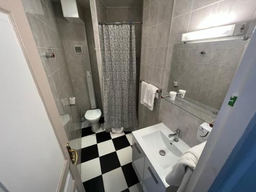 a bathroom with a black and white checkered floor at Hotel Celtic in Paris