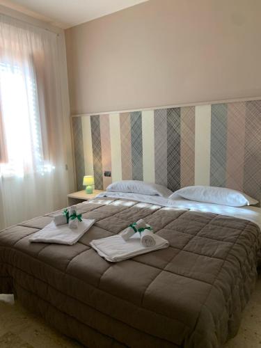 a bedroom with a large bed with towels on it at Villa Anna GuestHouse in Brindisi