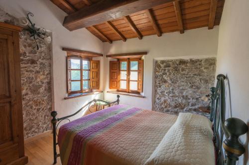 een slaapkamer met een bed en een stenen muur bij Agriturismo Monte Croce in Stazzema