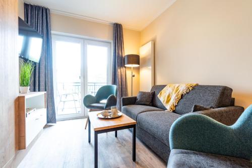 a living room with a couch and a table at Ostsee Apartmenthotel in Graal-Müritz