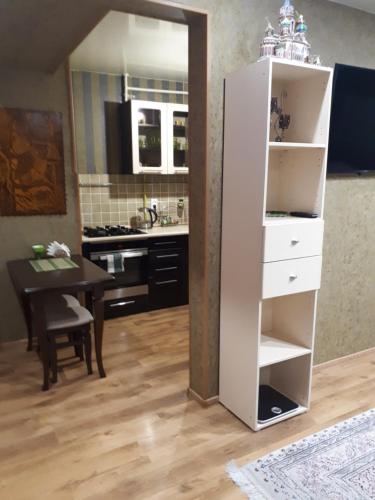una cocina con una estantería blanca y una mesa en Апартаменты на набережной в Актау, en Aktau