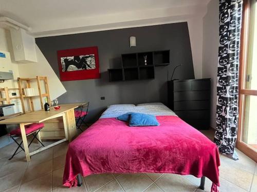 1 dormitorio con 1 cama con manta roja y escritorio en Appartamento A&S-Centro Argenta en Argenta