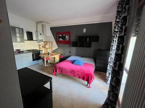 1 dormitorio con 1 cama con manta rosa en Appartamento A&S-Centro Argenta en Argenta
