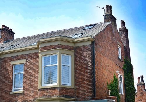 a brick house with a chimney on top of it at Pippin Lodge Lytham in Lytham St Annes