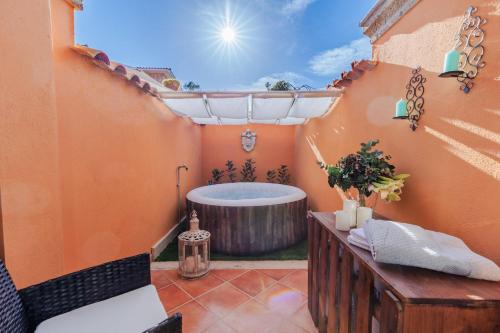 ein Badezimmer mit einer Badewanne im Freien in einem Haus in der Unterkunft Corallina, 2 Bedrooms Villa with Garden and Private Jacuzzi in Torvaianica