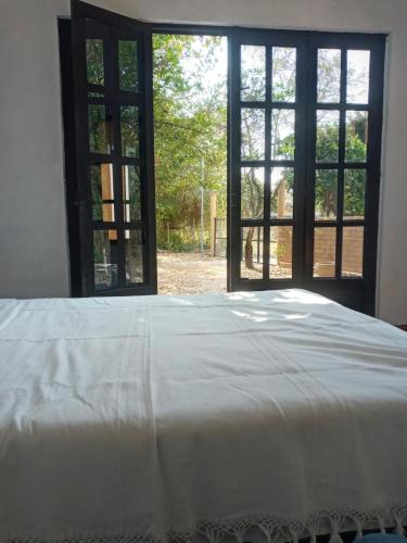 a bedroom with a white bed and a window at casa DON JULIAN in Tepoztlán