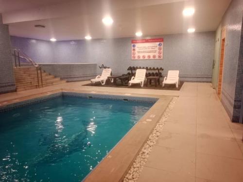 uma piscina com cadeiras e uma mesa num edifício em Bellevue Park Hotel em Taif