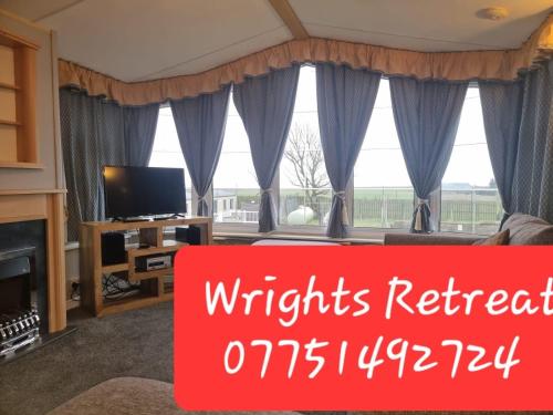 a living room with a fireplace and a tv at Wrights Retreat 4 Lunan View St Cyrus Caravan Park in Saint Cyrus