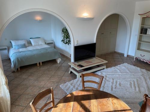 uma sala de estar com uma cama e uma mesa em Domaine des Tuilières avec piscine em Vallauris
