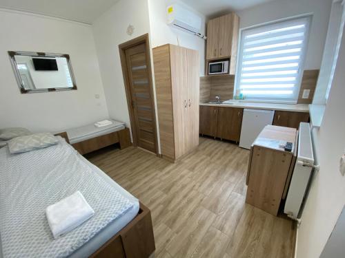 Habitación pequeña con cama y cocina en VÁR-LAK Apartman en Kisvárda