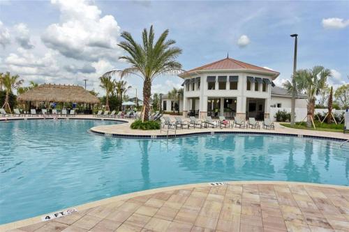 a large swimming pool with chairs and a building at Amazing 6BR Villa @ Storey Lake Resort Near Disney in Kissimmee