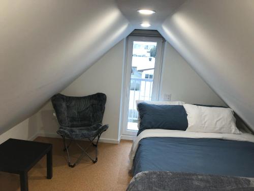 1 dormitorio con 1 cama, 1 silla y 1 ventana en Well Equipped Studio FOR NON-SMOKING GUESTS ONLY CITQ ЗO9467 en Longueuil