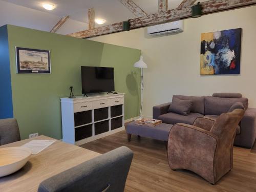 a living room with a couch and a tv at Heerlijk Appartement 'la bienvenue' in Venlo, Limburg in Venlo