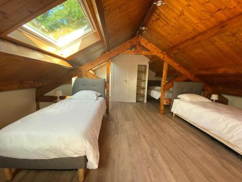 - une chambre mansardée avec 2 lits et une lucarne dans l'établissement Magnifique lodge dans la forêt de Fontainebleau, à Arbonne