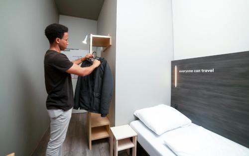 a man is standing in a room with a closet at a&o Wien Stadthalle in Vienna