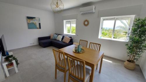 a living room with a table and chairs and a couch at Apartamento Kélyfos Beach by feriascomsol in Quarteira