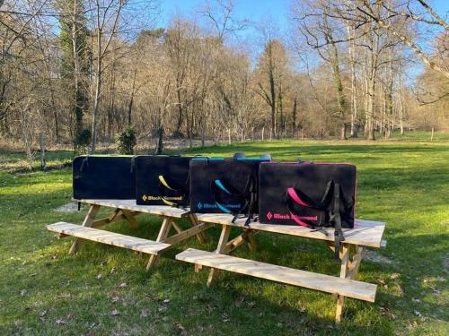 two bags sitting on top of a wooden picnic table at Magnifique lodge dans la forêt de Fontainebleau in Arbonne-la-Foret