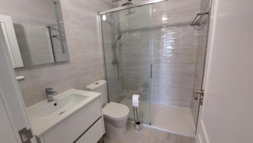 a bathroom with a shower and a toilet and a sink at Apartamento Kélyfos Beach by feriascomsol in Quarteira