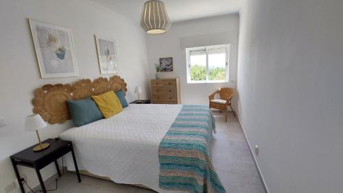 a bedroom with a large bed and a window at Apartamento Kélyfos Beach by feriascomsol in Quarteira