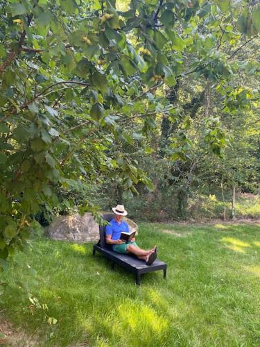 a man sitting on a bench in the grass at Magnifique lodge dans la forêt de Fontainebleau in Arbonne-la-Foret