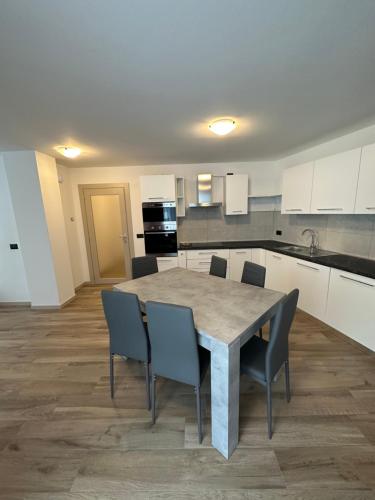 a kitchen with a table and chairs in a room at C&egrave;sa Sot Bosch in Canazei