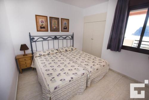 1 dormitorio con cama y ventana en Apartamento Coralbeach 318B - Grupo Turis, en Calpe