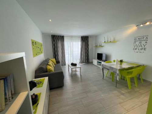 sala de estar con sofá y mesa de comedor en New Pistachio Apartment en Costa Teguise