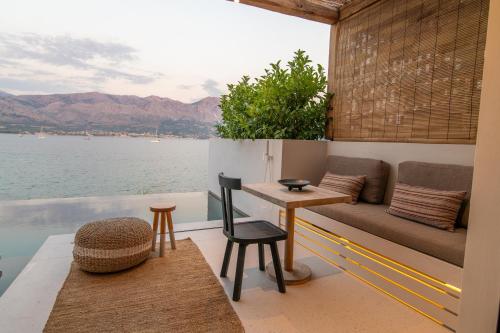 a living room with a couch and a view of the water at Amethyst Selene Paleros Couple's Hideaway in Paleros