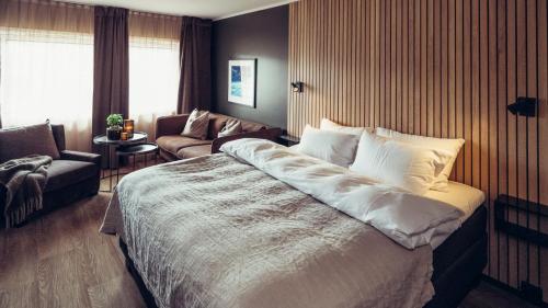ホーヴデンにあるHovdestøylenの大きなベッドとソファが備わるホテルルームです。