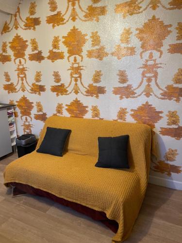 - un lit jaune avec deux oreillers dans une chambre dans l'établissement Lumineux appartements à 100m plage, à Berck-sur-Mer