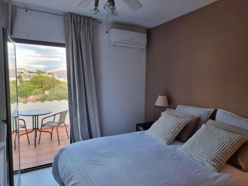 1 dormitorio con 1 cama y balcón con mesa en Vue magnifique mer et montagne, en Salobreña