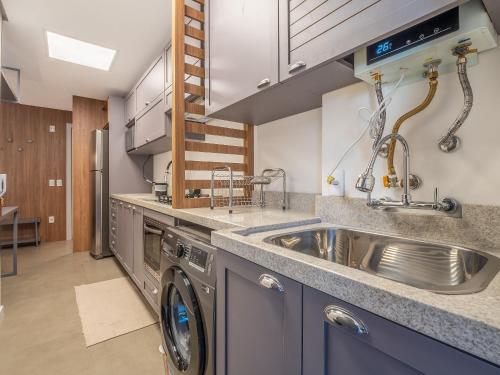 a kitchen with a sink and a washing machine at Volo Class 308 - A poucos passos Catedral de Pedra in Canela