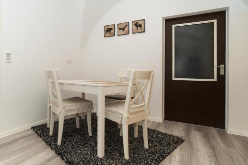 a dining room table with chairs and a black door at Apartmentvermietung Ingrid Bolkart - Vöhlino 2 in Illertissen