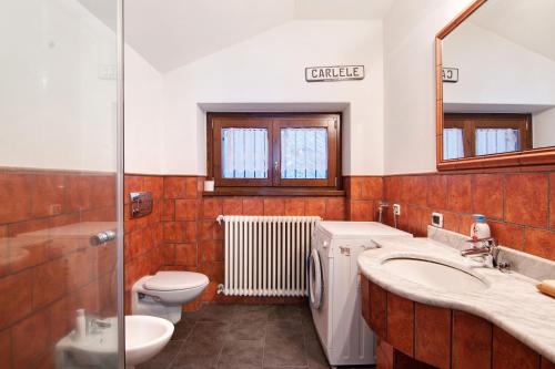 bagno con lavandino, servizi igienici e specchio di Bernhouse a Dorio