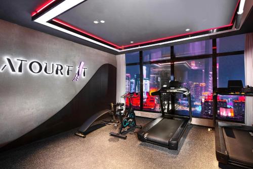 Atour Hotel Chongqing Jiefangbei Raffles City Riverview في تشونغتشينغ: صالة لياقة مع صالة رياضية مع جهاز ركض