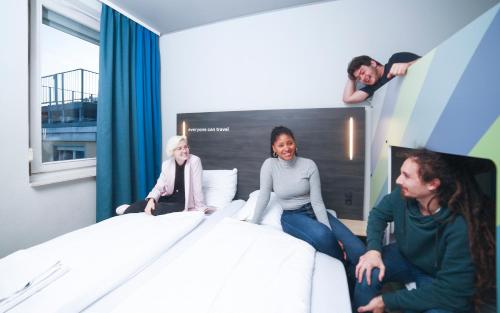 a group of people sitting on a bed at a&o Wien Stadthalle in Vienna