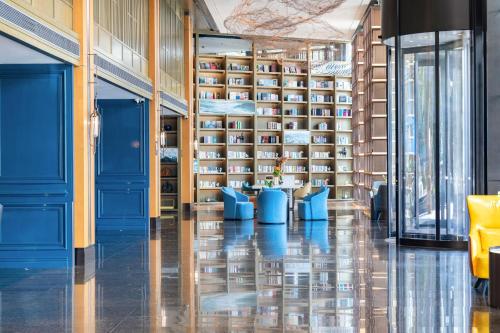una biblioteca con paredes azules y estanterías de libros en Atour X Hotel Zhuhai Lover Road Red Wave Bay Beach Seaview, en Zhuhai