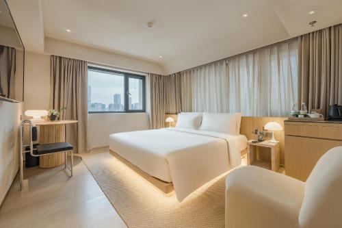 a hotel room with a white bed and a window at Atour S Hotel Beijing Guomao CBD - FunsCenter in Beijing