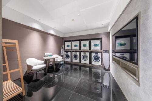 a laundry room with washing machines and a table and chairs at Atour X Hotel Zhuhai Lover Road Red Wave Bay Beach Seaview in Zhuhai