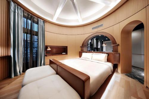 a bedroom with a bed and a couch at Z Hotel Shanghai Bund Shamei Building in Shanghai