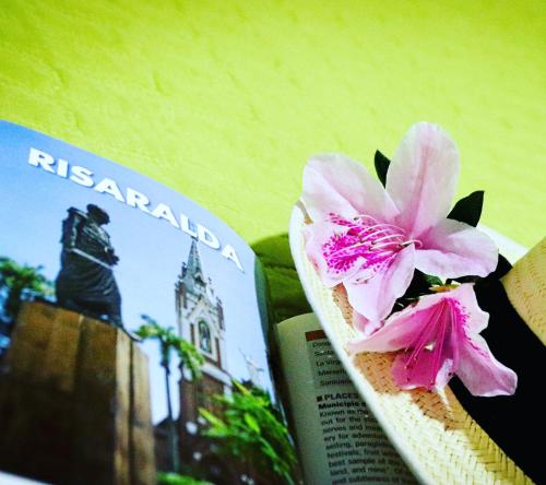 a book with a pink flower next to it at Hostal Don Jose in Santa Rosa de Cabal